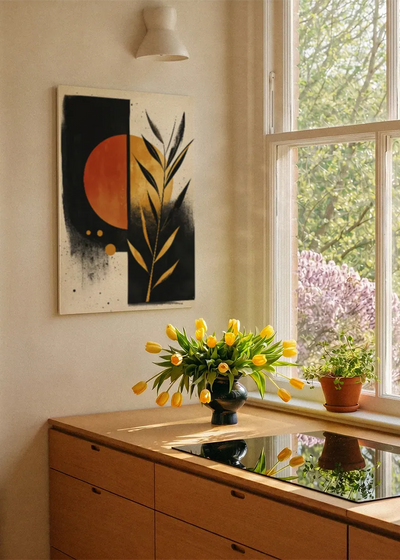 Akustikbillede med sorte og orange felter med gyldne blade, ved et vindue med en blomsterbuket i karmen