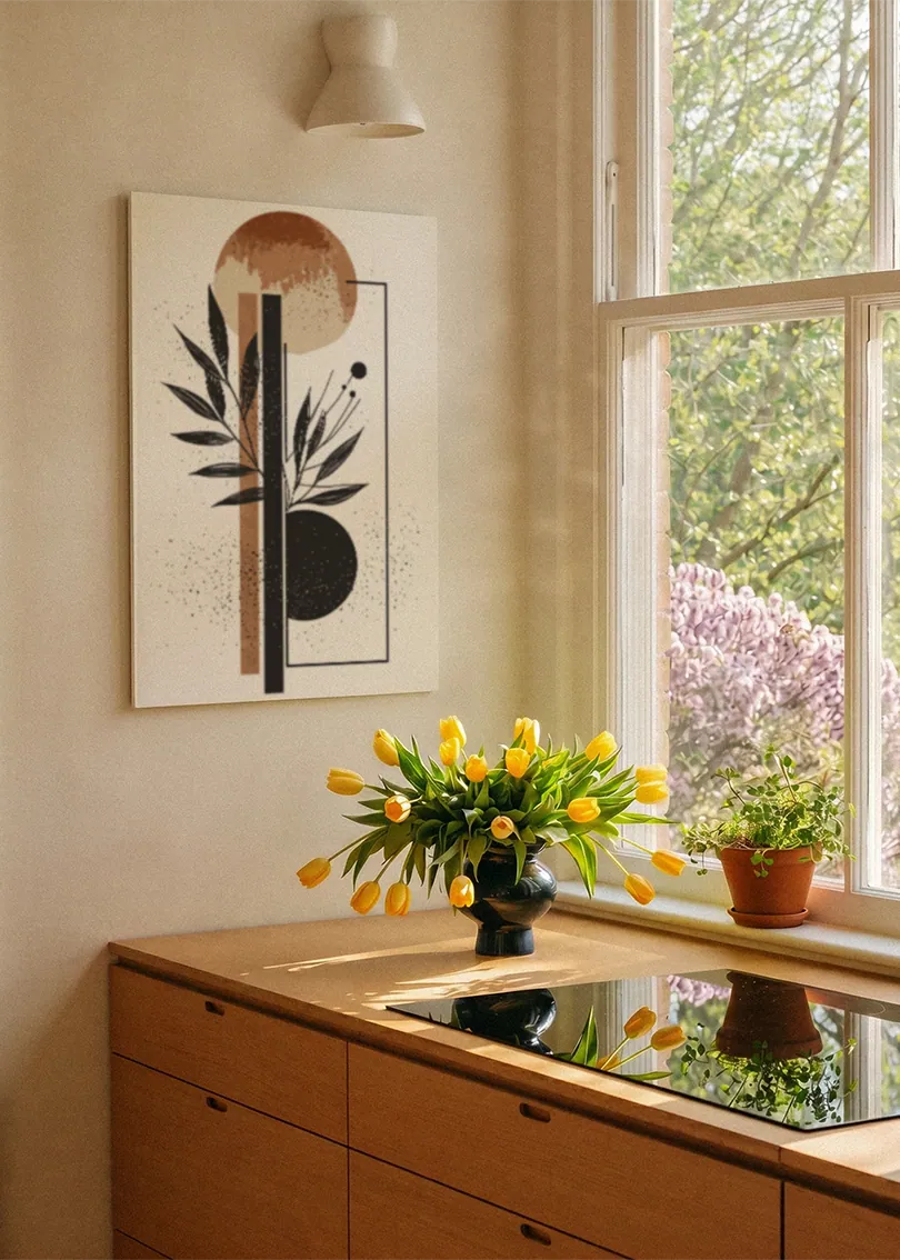 Akustikbillede med en terrakottacirkel med sorte grene i en tynd ramme, ved et vindue med en blomsterbuket i karmen