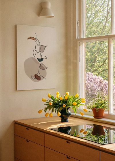 Akustikbillede med hvide blomster med brune former, ved et vindue med en blomsterbuket i karmen
