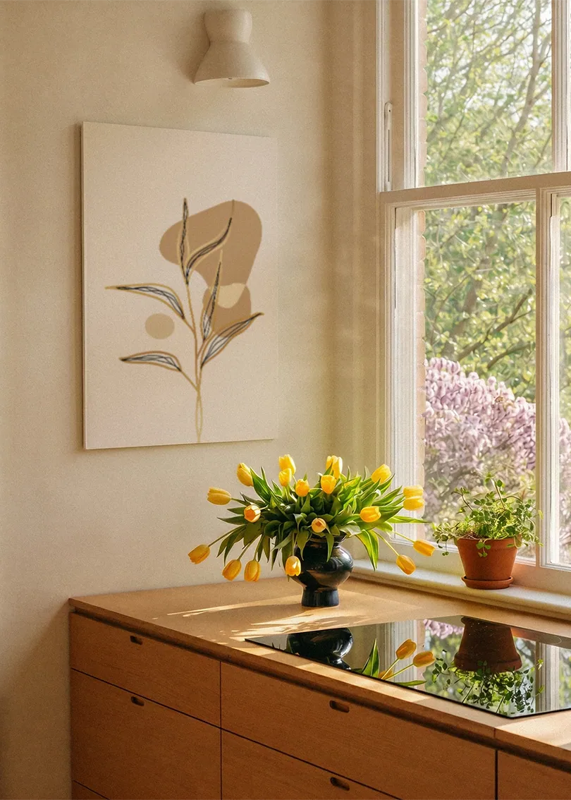 Akustikbillede med et gyldent blad med en brun form, ved et vindue med en blomsterbuket i karmen