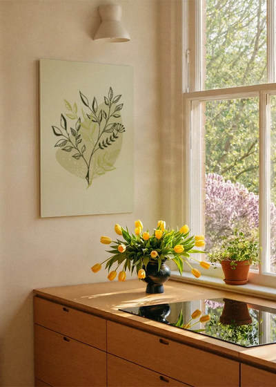 Akustikbillede med grønne blade på lysegrøn baggrund, ved et vindue med en blomsterbuket i karmen