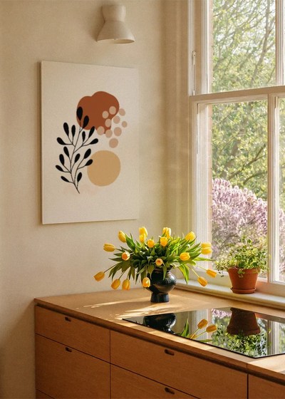 Akustikbillede med sorte blade med rustrøde prikker, ved et vindue med en blomsterbuket i karmen