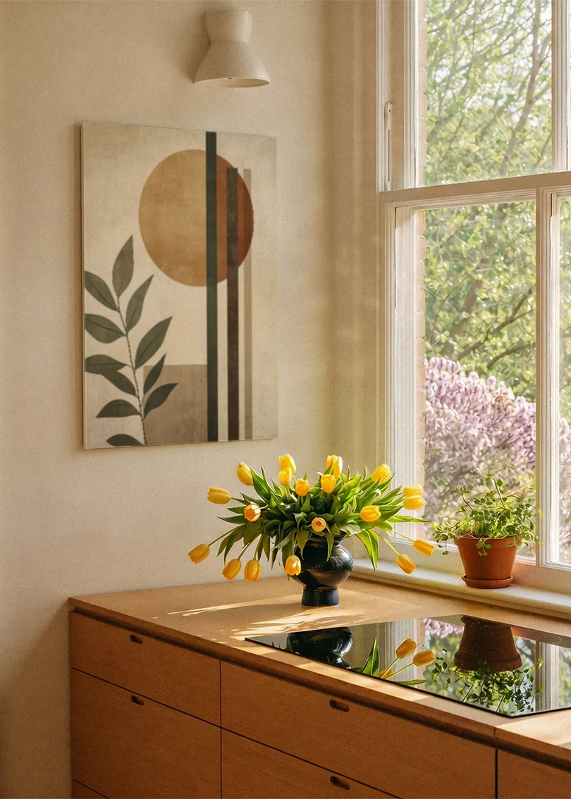 Akustikbillede med en beige cirkel bag grønne blade, ved et vindue med en blomsterbuket i karmen