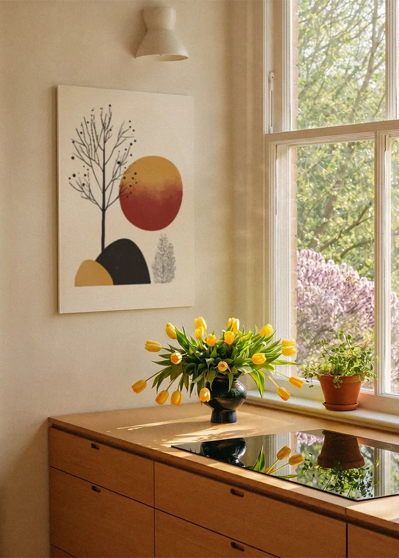Akustikbillede med en gylden cirkel med grene og sorte former, ved et vindue med en blomsterbuket i karmen