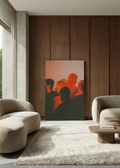 Akustikbillede med silhuetter i orange og sort, i en lounge med bugtet sofa mod valnød