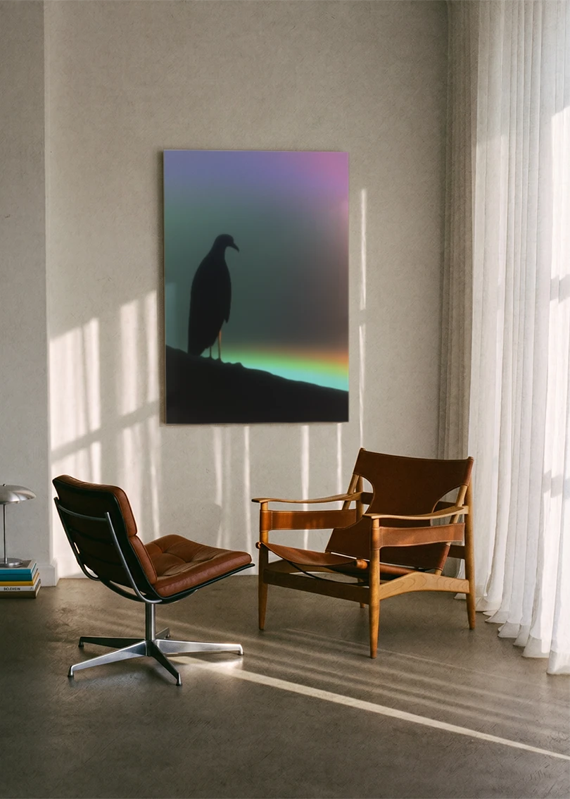Akustikbillede med en fugl på en gren mod en regnbuegradient, ophængt over en brun lænestol ved vinduet