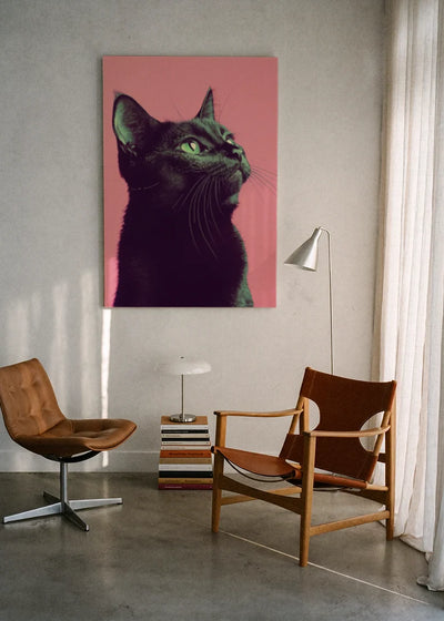 Akustikbillede med en sort kat på pink baggrund, ophængt over en lænestol ved gardinet med gulvlampe