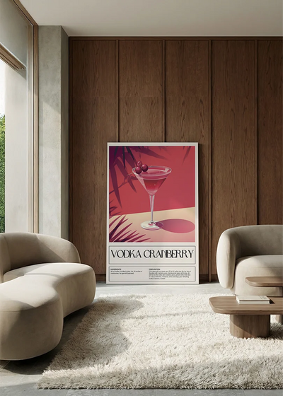 Akustikbillede med en retro cocktailplakat med Vodka Cranberry, i en lounge med bugtet sofa mod vægpanel i valnød