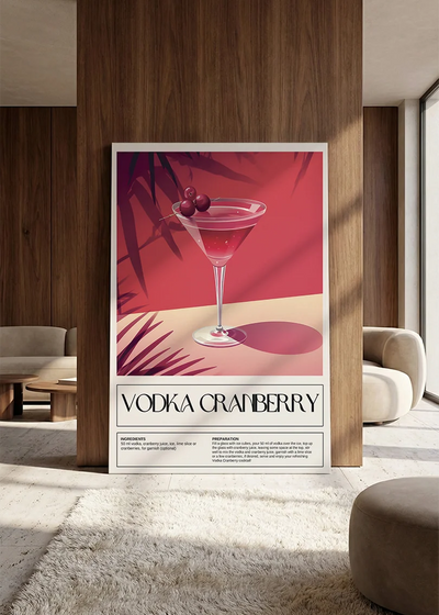 Akustikbillede med en retro cocktailplakat med Vodka Cranberry, lænet mod vægpanel i valnød ved sofaen