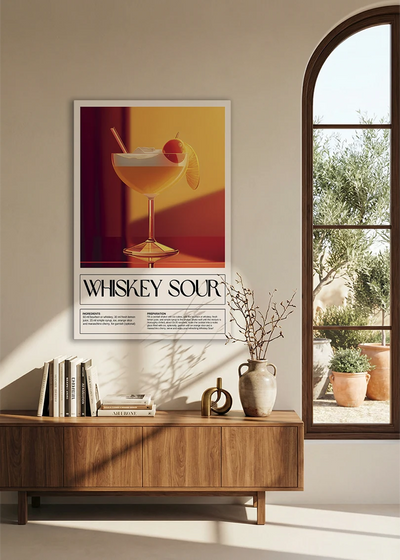 Akustikbillede med en retro cocktailplakat med Whiskey Sour, over en skænk i valnød ved et buet vindue