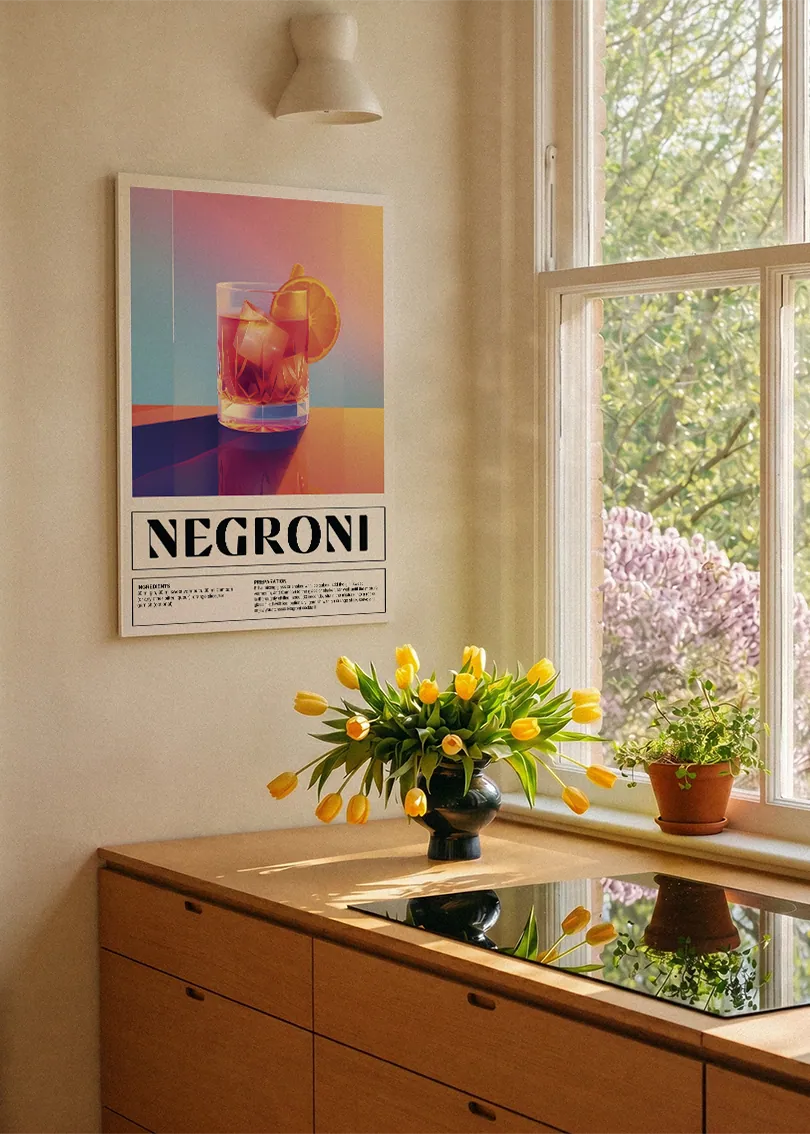 Akustikbillede med en retro cocktailplakat med Negroni, ved et køkkenvindue med gule tulipaner