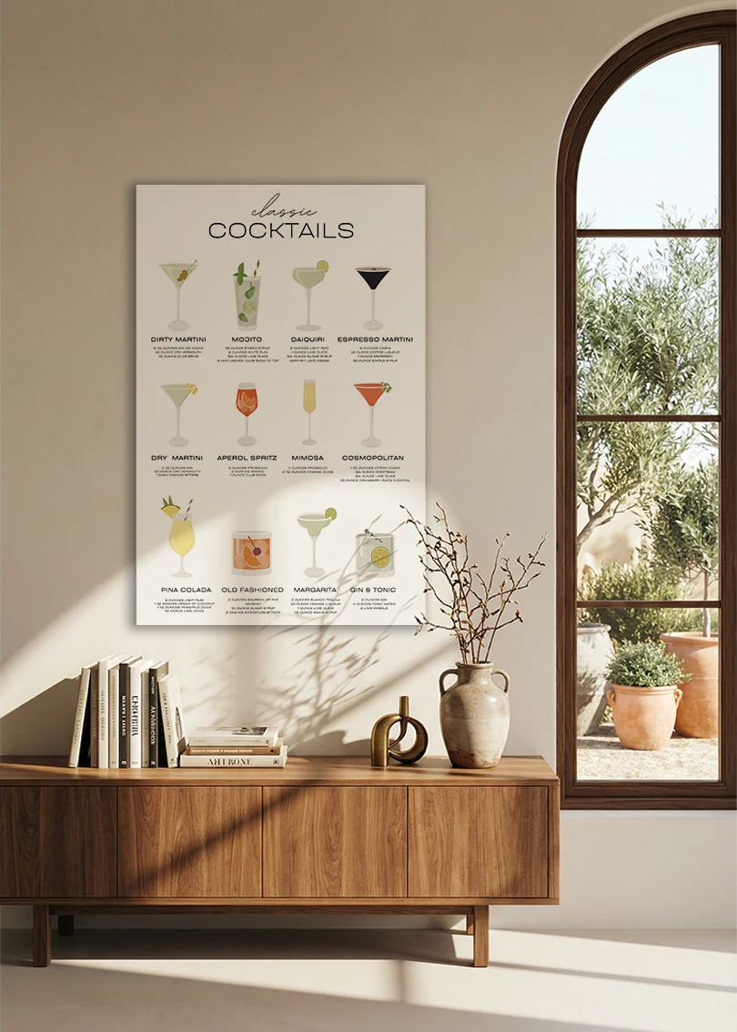 Akustikbillede med en oversigtsplakat med klassiske cocktails, over en skænk i valnød ved et buet vindue