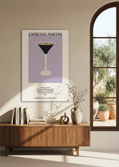 Akustikbillede med en minimalistisk cocktailplakat med Espresso Martini, over en skænk i valnød ved et buet vindue