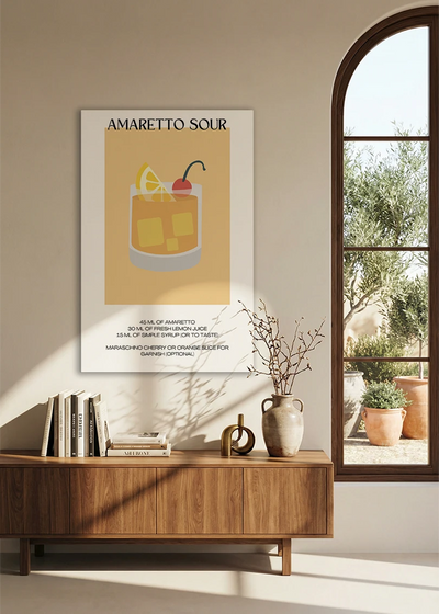 Akustikbillede med en minimalistisk cocktailplakat med Amaretto Sour, over en skænk i valnød ved et buet vindue