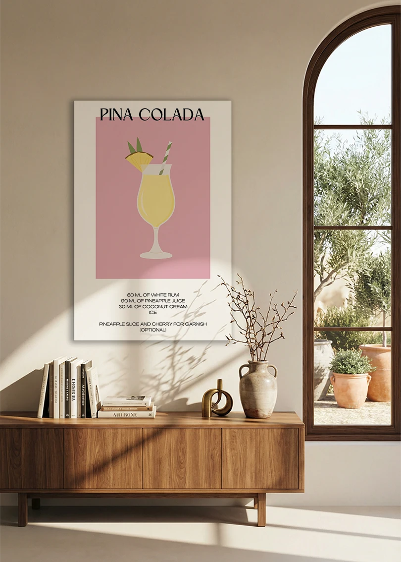 Akustikbillede med en minimalistisk cocktailplakat med Pina Colada, over en skænk i valnød ved et buet vindue