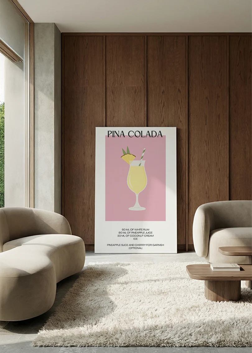 Akustikbillede med en minimalistisk cocktailplakat med Pina Colada, i en lounge med bugtet sofa mod vægpanel i valnød