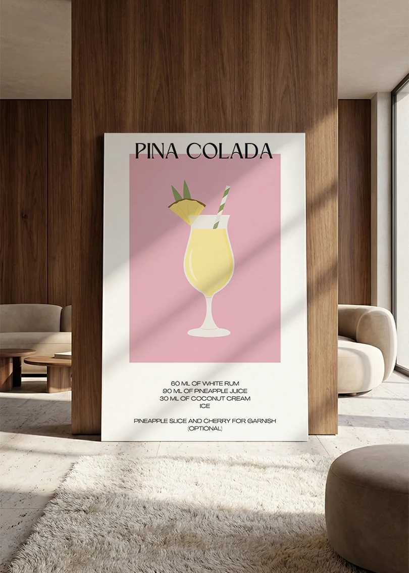 Akustikbillede med en minimalistisk cocktailplakat med Pina Colada, lænet mod vægpanel i valnød ved sofaen
