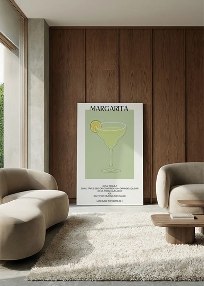 Akustikbillede med en minimalistisk cocktailplakat med Margarita, i en lounge med bugtet sofa mod vægpanel i valnød