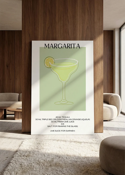 Akustikbillede med en minimalistisk cocktailplakat med Margarita, lænet mod vægpanel i valnød ved sofaen