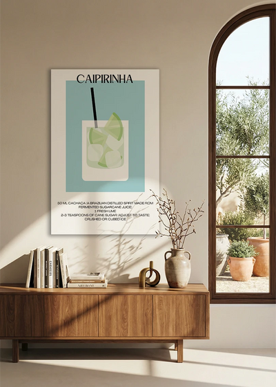 Akustikbillede med en minimalistisk cocktailplakat med Caipirinha, over en skænk i valnød ved et buet vindue