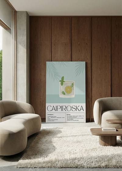 Akustikbillede med en retro cocktailplakat med Caipiroska, i en lounge med bugtet sofa mod vægpanel i valnød