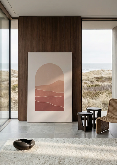 Akustikbillede med bølgede bakker i rosa og rødt, i stort format ved et panoramavindue med havudsigt