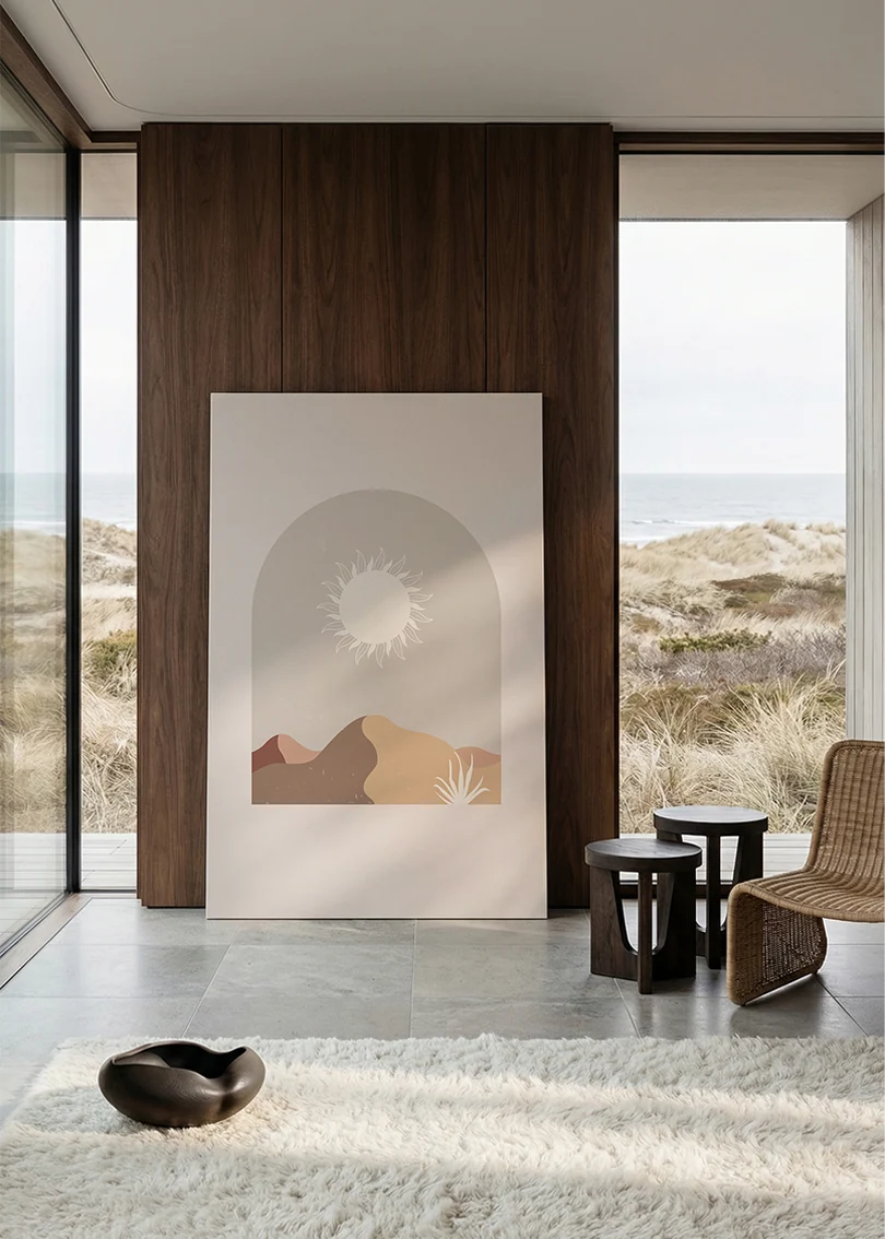 Akustikbillede med en hvid sol over bjerge i beige, i stort format ved et panoramavindue med havudsigt
