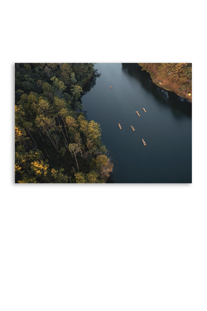 Akustikbillede med dronefoto af en flod gennem efterårsskov med kajakker