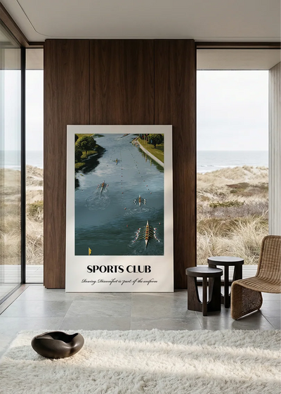 Akustikbillede med en sportsplakat med en polokamp på grøn bane, i et rum med panoramavindue og havudsigt